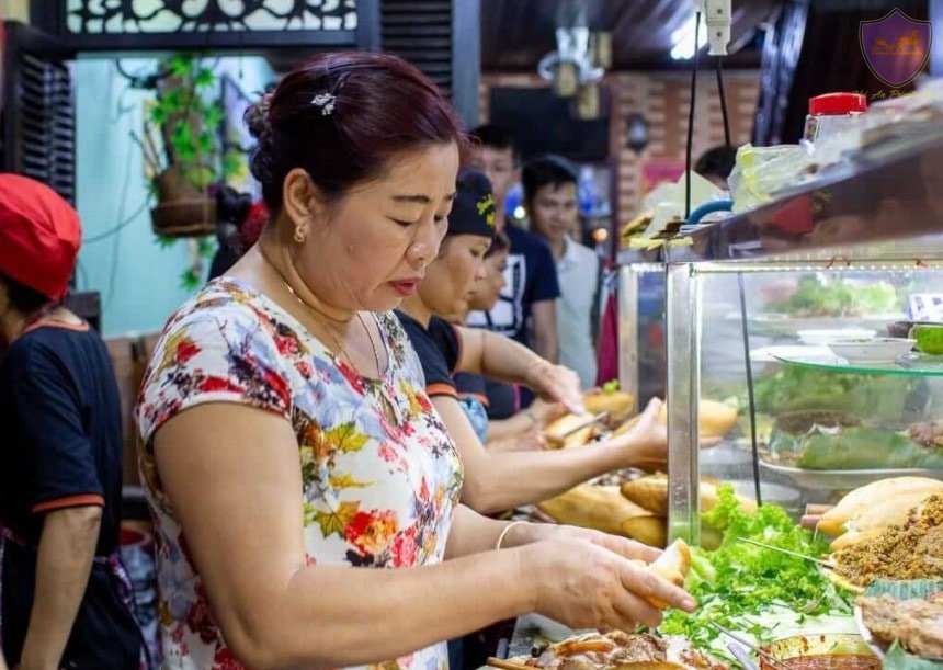 Bà Phượng, chủ quán, đang tỉ mỉ chuẩn bị bánh mì cho thực khách