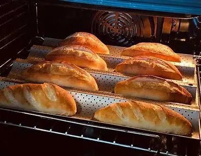 Bánh mì baguette vàng giòn trên khay nướng sau khi làm nóng