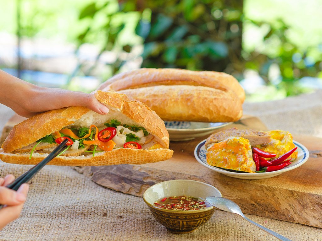 Bánh mì chả cá Nha Trang nóng hổi, miếng chả cá dai ngọt hòa quyện cùng rau thơm.
