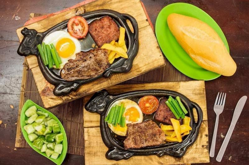 Bánh mì chảo hình con bò độc đáo với khoai tây, trứng ốp la và xúc xích, mang đến trải nghiệm ẩm thực đường phố Hà Nội thú vị