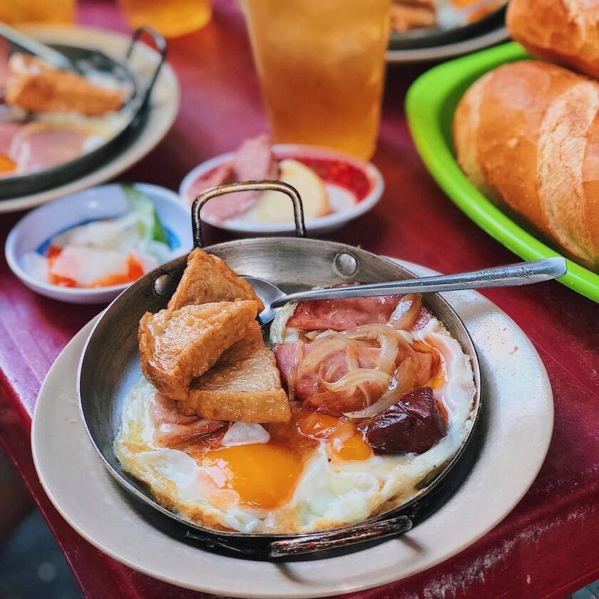 Bánh mì chảo Hoà Mã với đa dạng topping như trứng, dăm bông và xúc xích