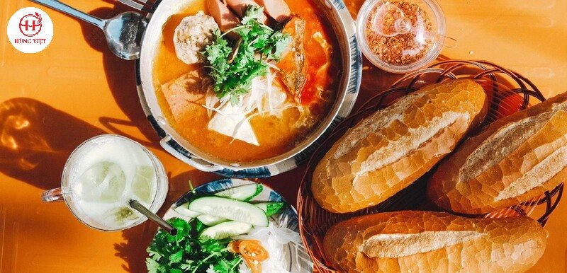 Bánh mì chảo xíu mại được bày biện đẹp mắt cùng nhiều loại topping hấp dẫn như pate, trứng, rau sống.