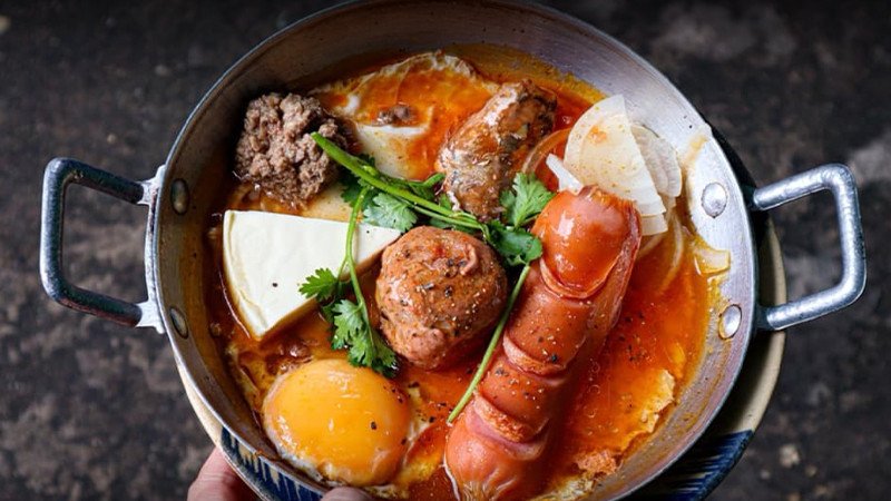 Bánh mì chảo Xuân Lạc với xúc xích chất lượng và các nguyên liệu tươi ngon trên chảo gang nóng, thể hiện mức bánh mì chảo giá bao nhiêu hợp lý