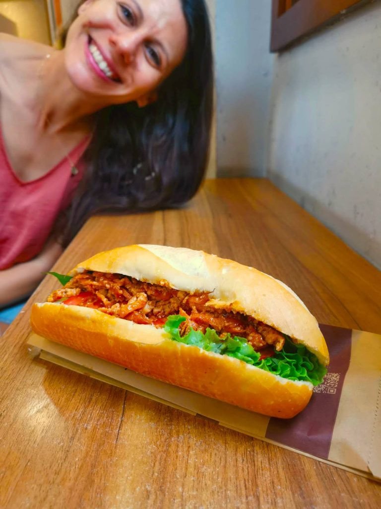 Bánh mì chay với đậu phụ, ớt và xà lách trên bàn gỗ, một lựa chọn ẩm thực chay hấp dẫn tại Thành phố Hồ Chí Minh.