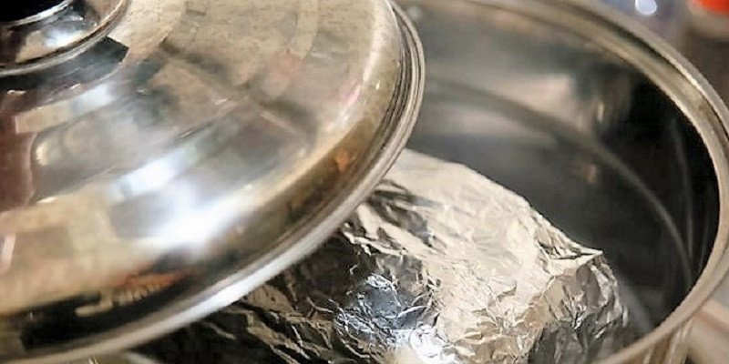 Bánh mì cũ được bọc kín trong giấy bạc và đặt trong nồi để hâm nóng trên bếp