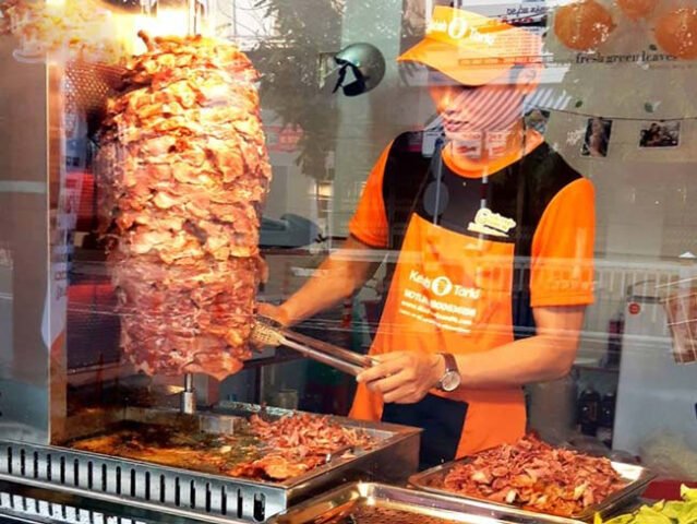Bánh mì doner kebab nóng hổi với thịt nướng xiên quay thơm lừng, sẵn sàng phục vụ thực khách.