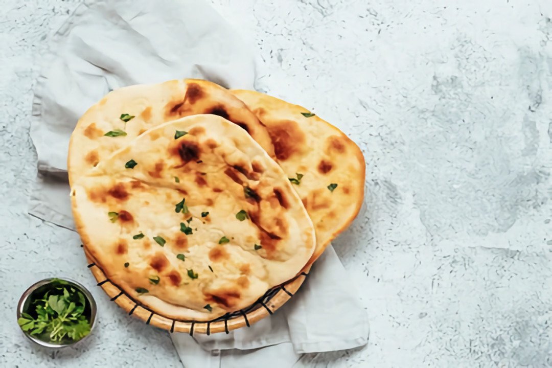 Bánh mì Naan tươi nóng hổi, thường không phải đồ chay do chứa sữa chua và bơ ghee