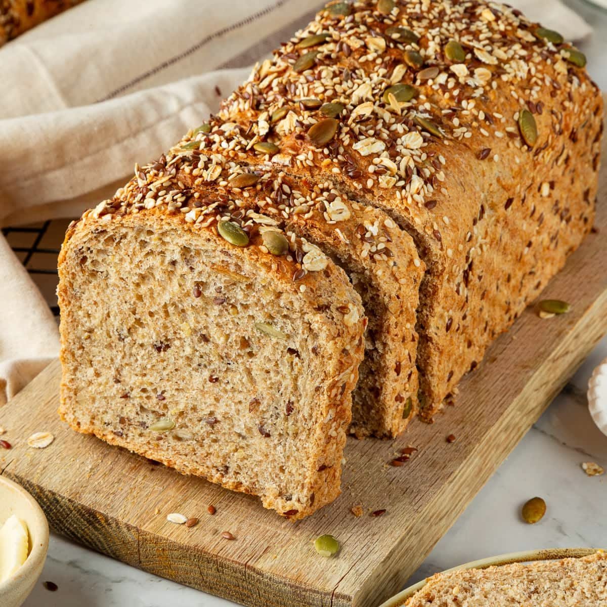 Bánh Mì Nguyên Cám Tous Les Jours: Lợi Ích & Sử Dụng Hiệu Quả 5 Ổ bánh mì nguyên cám cắt lát, đặt trên thớt gỗ, sẵn sàng để thưởng thức