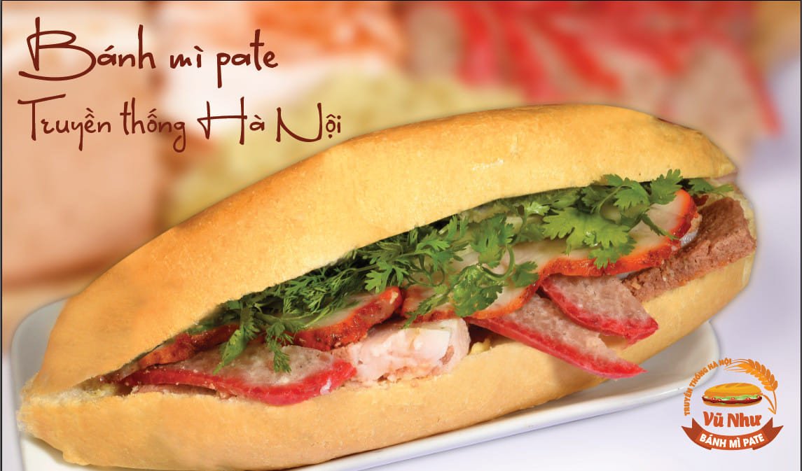 Bánh mì pate truyền thống Hà Nội cắt đôi, lộ rõ phần nhân pate, thịt nguội, rau thơm và dưa chuột tươi ngon