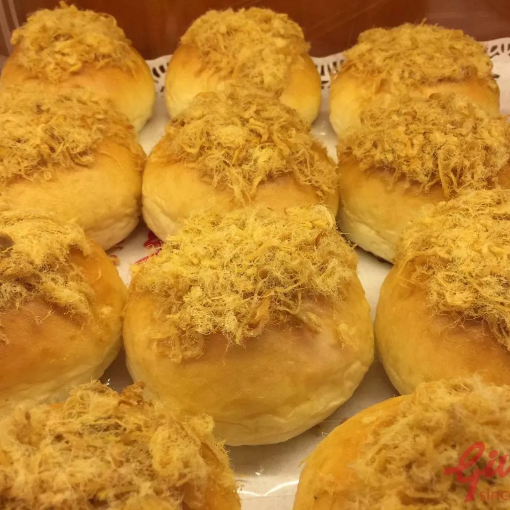 Bánh mì phô mai tan chảy Việt Hương được bày trên đĩa cùng cà phê và trái cây tươi, tạo thành bữa sáng hấp dẫn.