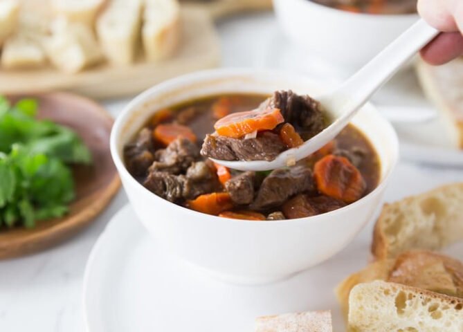 Bát bò sốt vang nóng hổi ăn kèm bánh mì giòn rụm, minh họa món bánh mì sốt vang in English.