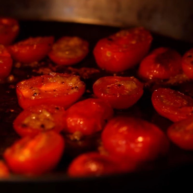 Cà chua bi đang được nướng trong lò cho món bánh mì kẹp phô mai