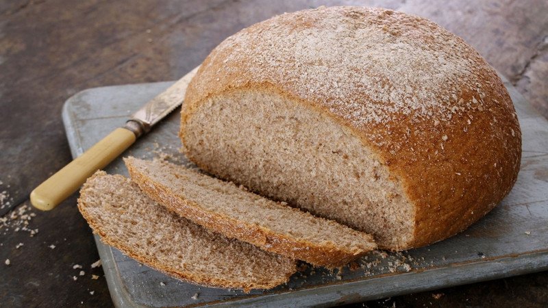 Các lát bánh mì nâu hoặc bánh mì nguyên cám, minh họa sự đa dạng về lượng calo trong bánh mì và vai trò của khẩu phần ăn với việc kiểm soát cân nặng.