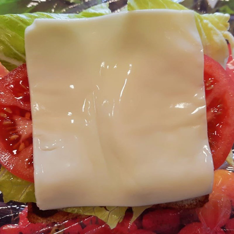 Các nguyên liệu như xà lách, cà chua, phô mai được xếp lớp trên bánh mì sandwich