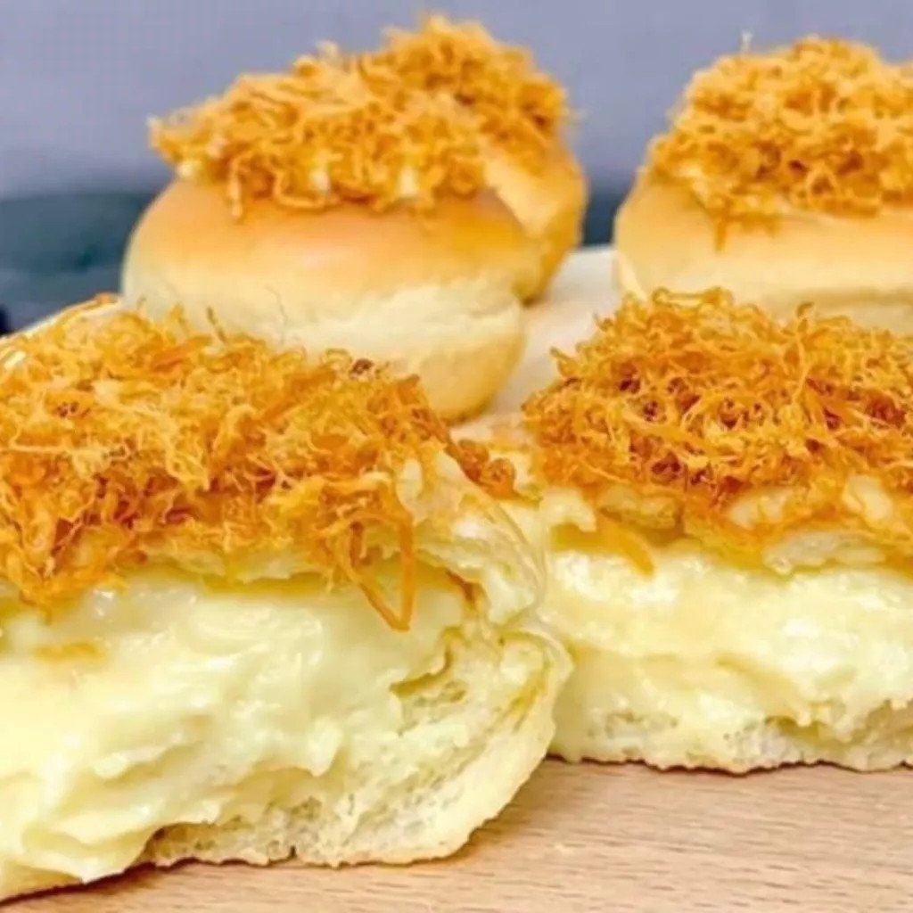 Cận cảnh nhân phô mai tan chảy béo ngậy, vàng óng bên trong bánh mì, kích thích vị giác.