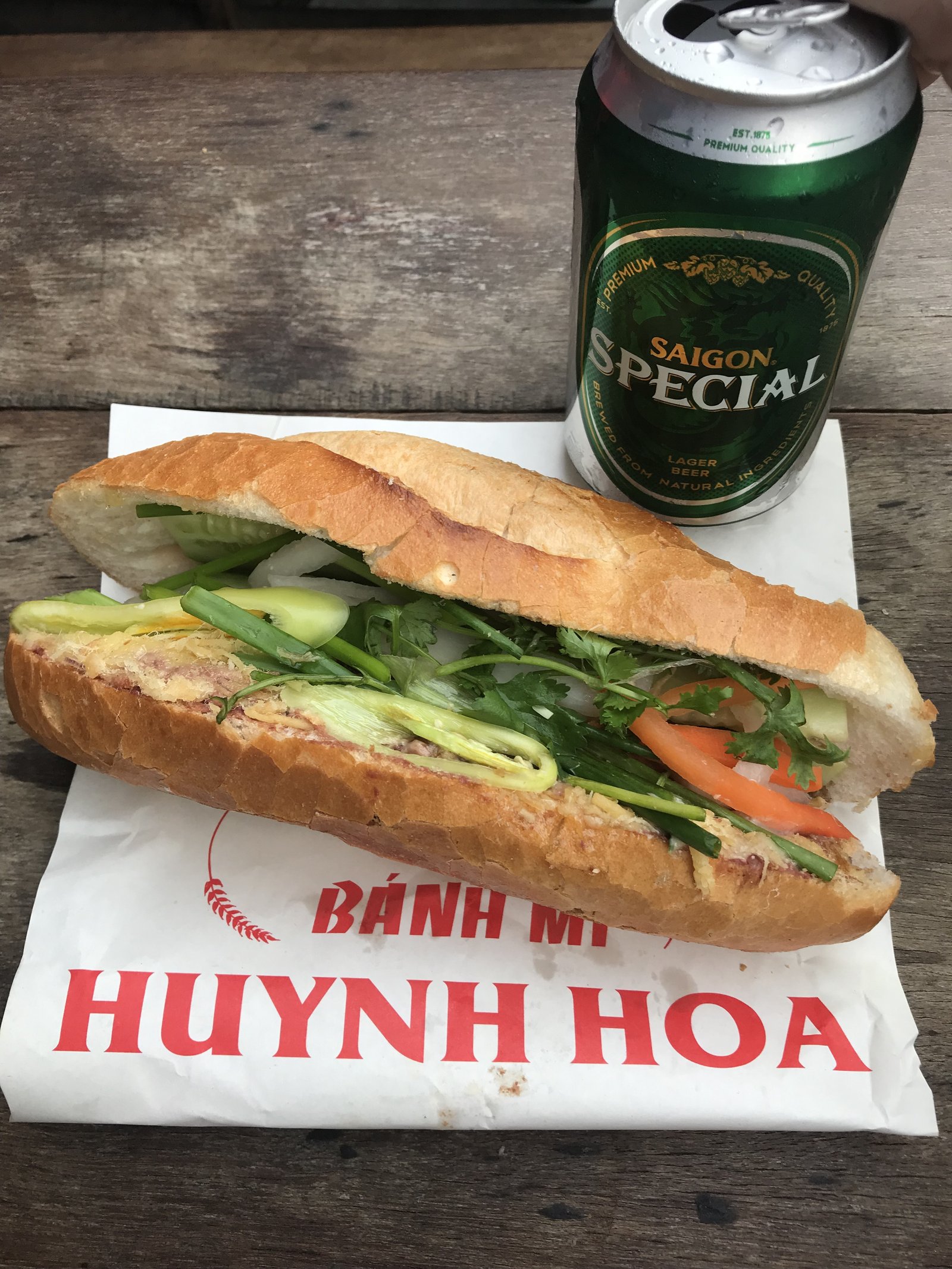 Cận cảnh ổ bánh mì đầy ắp nhân thịt nguội, chả lụa và rau thơm, một phần đặc trưng của bánh mì Huỳnh Hoa menu.