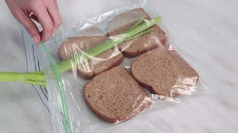 Cần tây xanh tươi được đặt cùng bánh mì sandwich trong túi, giúp duy trì độ ẩm và kéo dài thời gian bảo quản