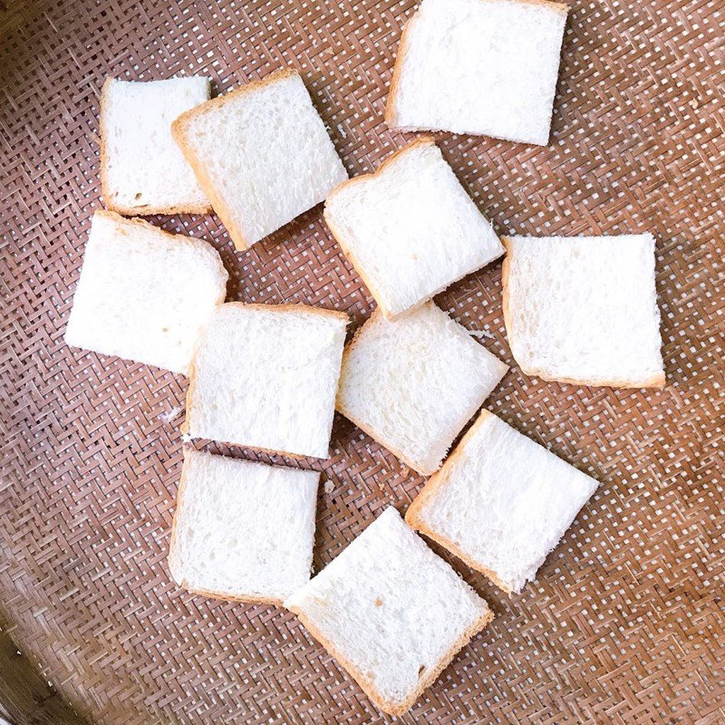 Cắt bánh mì sandwich thành các miếng vuông nhỏ để chuẩn bị làm bánh mì trứng nướng