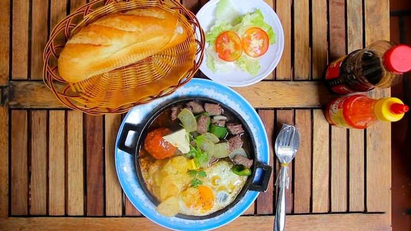 Chảo bánh mì chảo đầy ắp topping và nước sốt hấp dẫn tại quán 176 Đinh Tiên Hoàng, mô tả chi tiết bánh mì chảo giá bao nhiêu kèm theo sự thịnh soạn