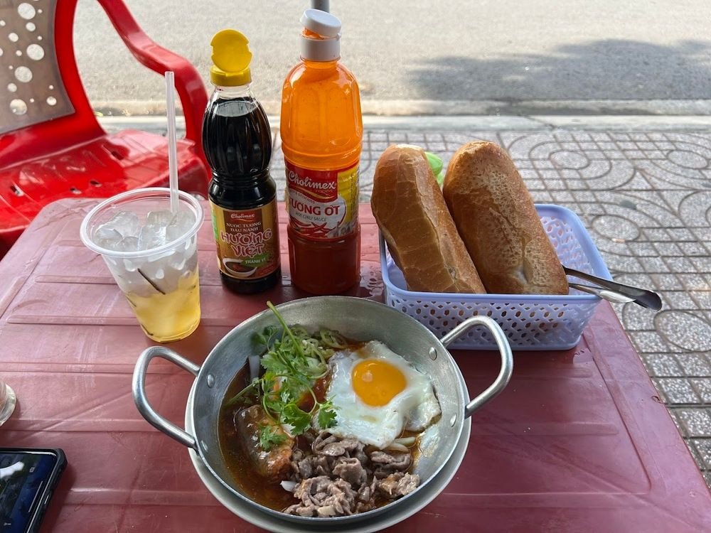 Chảo bánh mì chảo đầy đặn với trứng, thịt bò, xá xíu và nước sốt thơm ngon