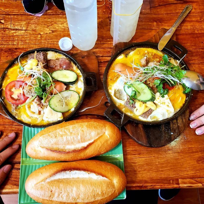 Chảo bánh mì đầy ắp topping bao gồm trứng, xúc xích và rau