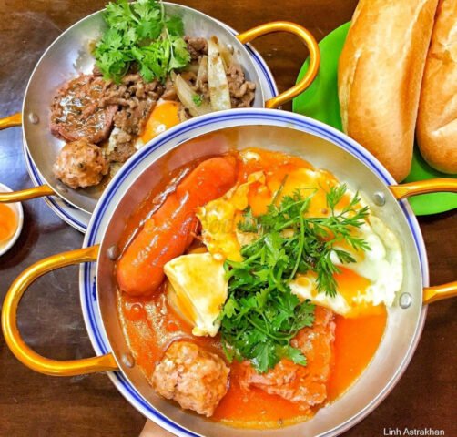 Chảo bánh mì thập cẩm đầy đặn với trứng ốp la, pate béo ngậy và thịt nguội tại một quán bánh mì chảo ngon Hà Nội