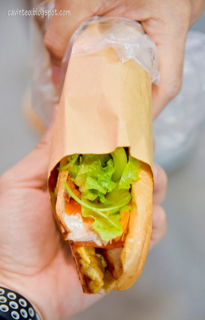 Chiếc bánh mì Thập Cẩm nóng hổi được gói cẩn thận, sẵn sàng để khách hàng mang về từ Banh Mi Mama