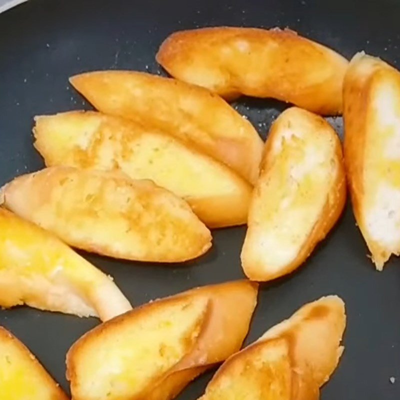 Chiên bánh mì với bơ trên chảo nóng đến khi vàng giòn