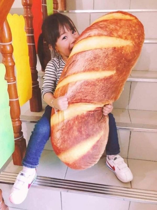 Cô gái ôm gối ôm bánh mì, thể hiện sự yêu thích và thoải mái