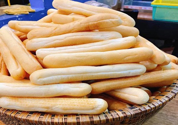 Dàn bánh mì que nhỏ xinh, vàng ươm chuẩn bị nướng tại một lò bánh chuyên nghiệp