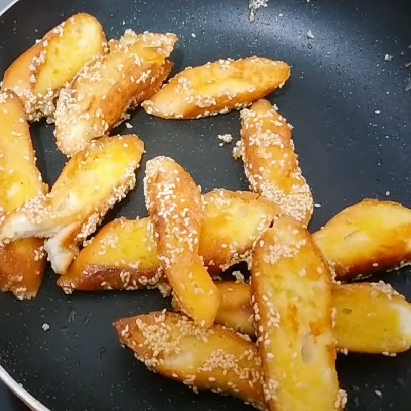 Đảo đều bánh mì đã chiên với sốt bơ đường và vừng