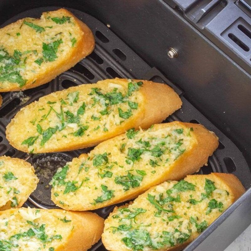 Đặt bánh mì đã phết bơ mật vào nồi chiên không dầu để nướng giòn.
