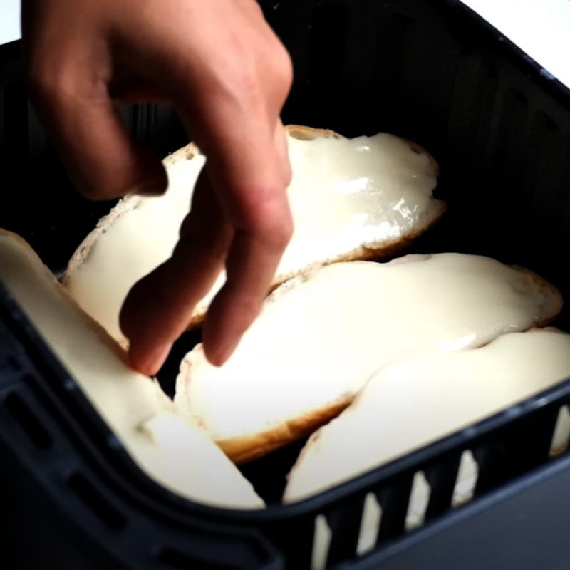 Đặt bánh mì đã phết phô mai vào nồi chiên không dầu để nướng