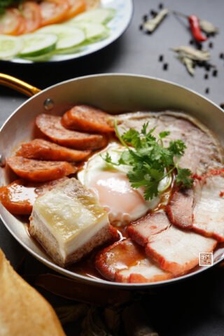 Đĩa bánh mì chảo nóng hổi với trứng ốp la, pate và các loại thịt ăn kèm