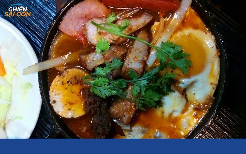 Đĩa bánh mì chảo thập cẩm nóng hổi với trứng ốp la, xúc xích và pate tại quán cô 3 Hậu