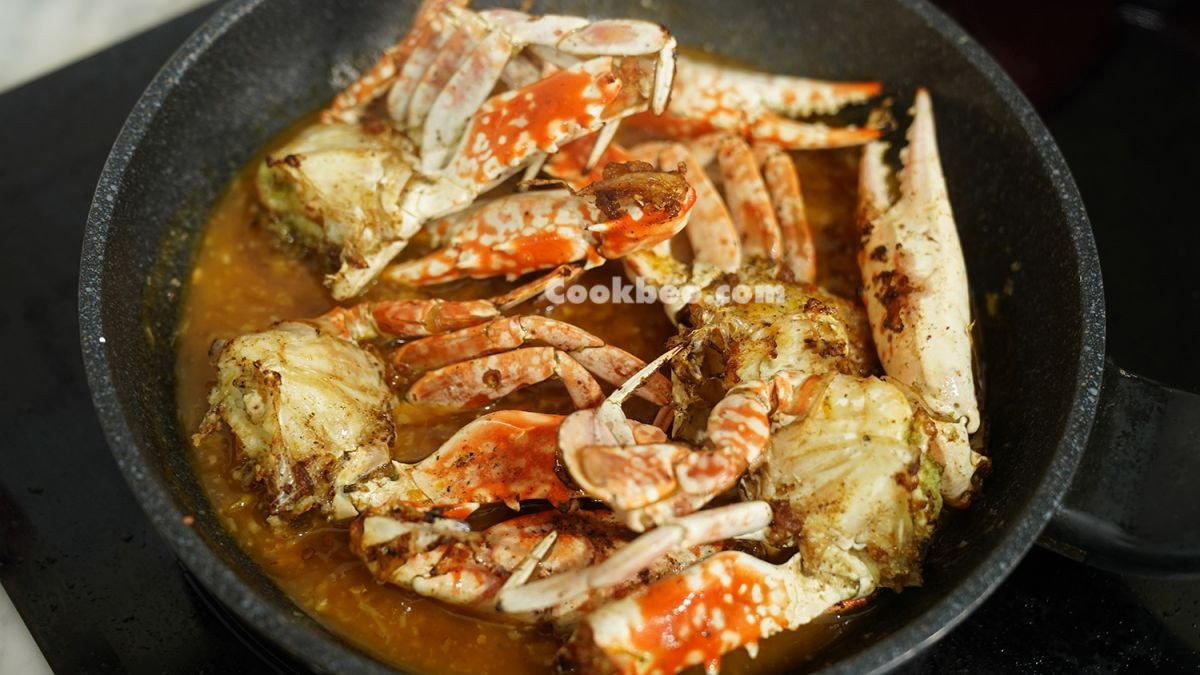 Ghẹ tươi đang được rang cùng sốt me sánh mịn, thơm lừng