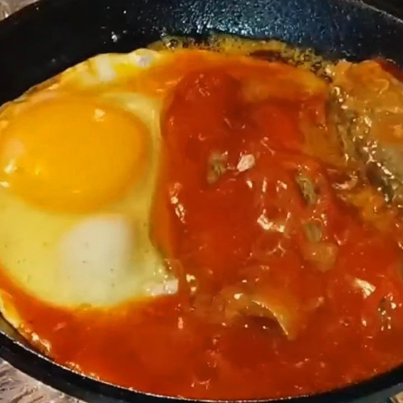 Hình ảnh đang chế biến cá hộp và trứng ốp la trên chảo