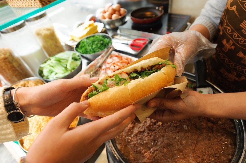 Hình ảnh một bữa sáng nhanh gọn với bánh mì heo quay, thể hiện sự tiện lợi và giá trị năng lượng cho ngày mới.