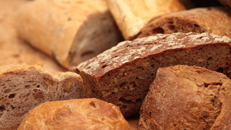 Hình ảnh một người đang ăn bánh mì vào buổi tối, tượng trưng cho việc không nên ăn bánh mì bơ sữa vào thời điểm này