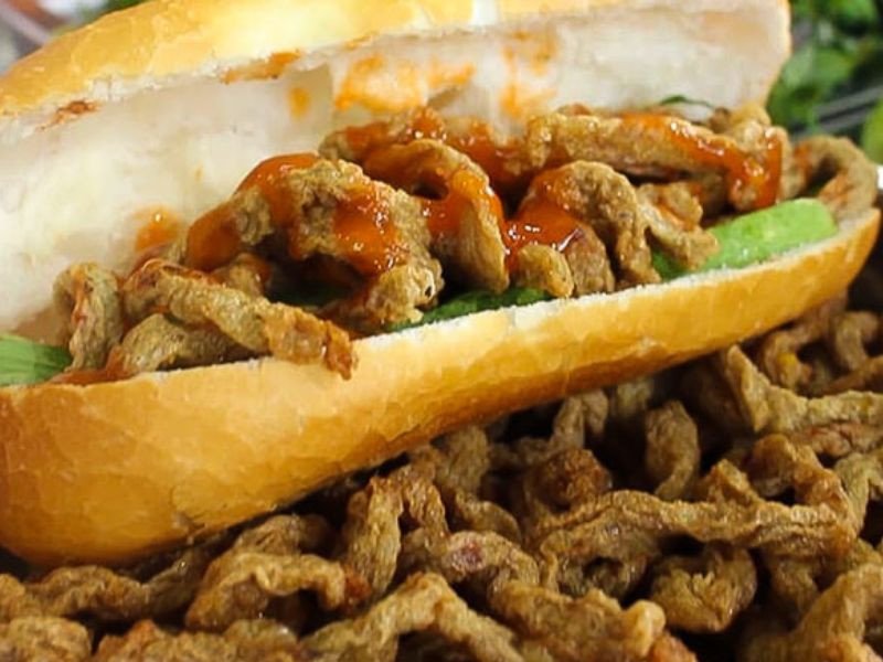 Hình ảnh một ổ bánh mì chả cá thơm ngon với các loại rau và nước sốt, thể hiện sự hấp dẫn của món ăn.