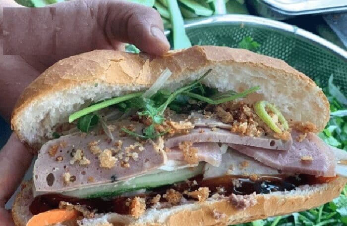 Hoàn thành một ổ bánh mì chả bò Đà Nẵng đầy đặn, rưới nước sốt thơm lừng