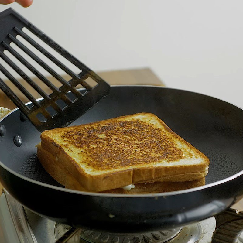 Kẹp ba loại phô mai Mozzarella, Cheddar và Parmesan giữa hai lát bánh mì sandwich