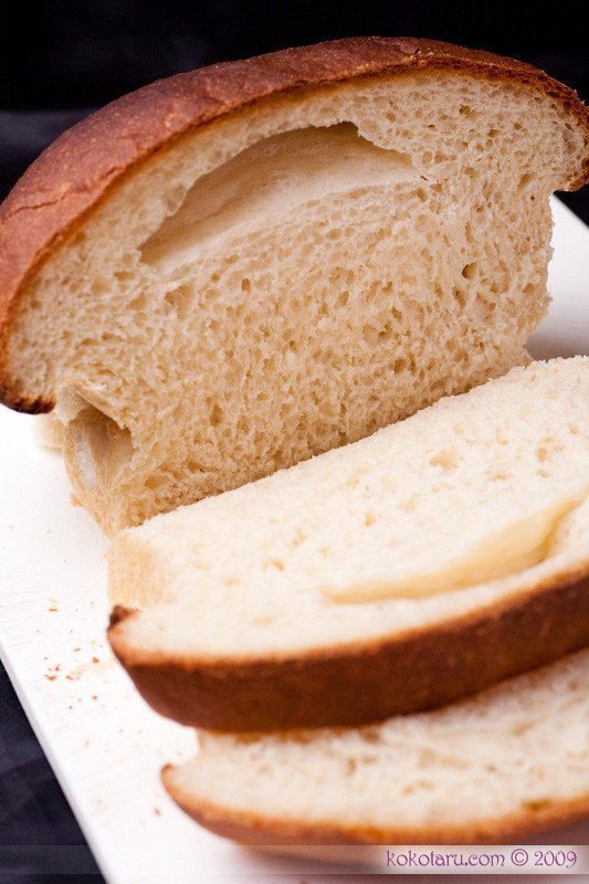 Khối bột bánh mì đang ủ nở phồng lên gấp đôi trong tô.