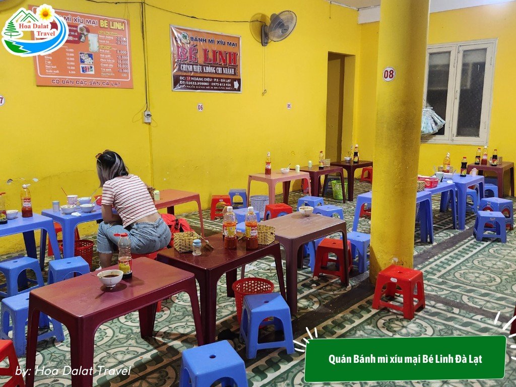 Không gian quán bánh mì xíu mại Bé Linh với tone màu vàng nổi bật và bàn ghế nhựa sạch sẽ