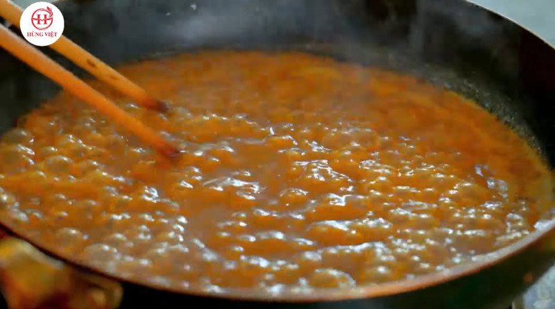 Khuấy đều nước sốt xíu mại trên bếp