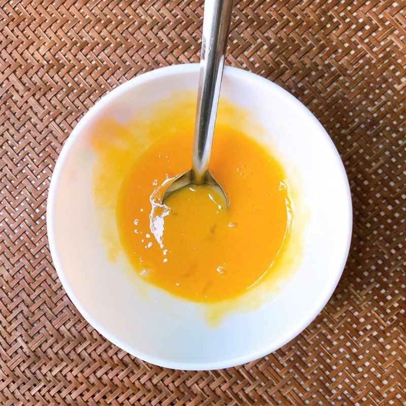 Khuấy đều trứng gà và sữa đặc trong chén để tạo hỗn hợp trứng sữa cho bánh mì trứng nướng