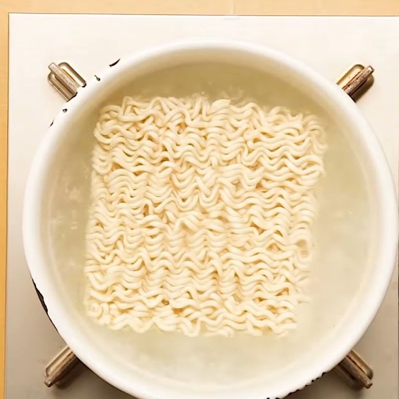 Luộc mì gói chuẩn bị cho nhân bánh mì sandwich phô mai kéo sợi