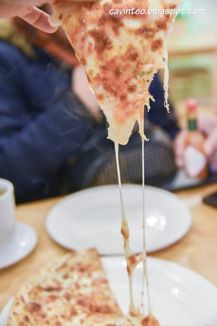 Miếng pizza Margherita nóng hổi với phô mai tan chảy, một lựa chọn bên cạnh bánh mì Sapa.
