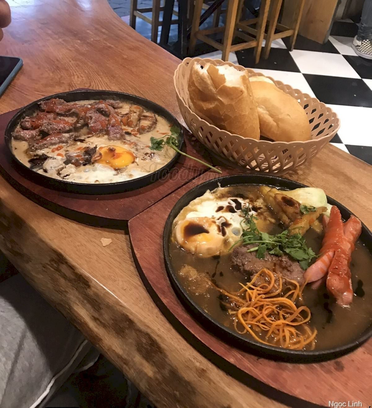 Món bánh mì chảo thập cẩm nóng hổi với pate, trứng và khoai tây, kèm salad tươi mát tại quán ăn ngon Hà Nội