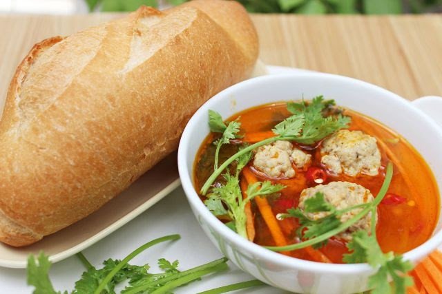 Món bánh mì xíu mại Đà Lạt với chén xíu mại nóng hổi và bánh mì giòn, là biến thể bánh mì Việt Nam độc đáo của xứ sở ngàn hoa